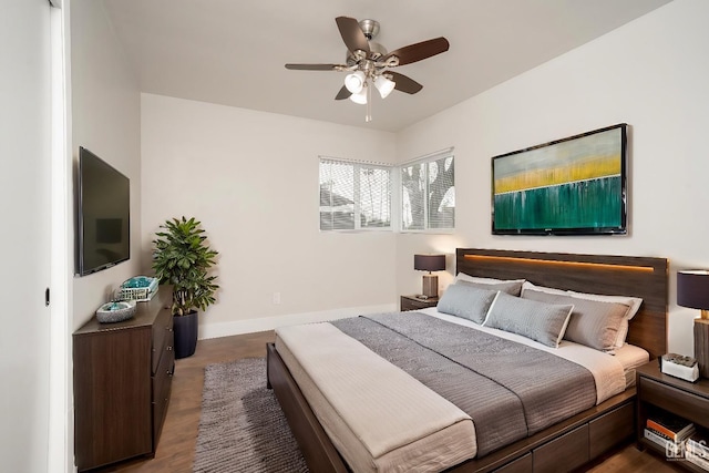 bedroom with a ceiling fan, dark wood-style flooring, and baseboards