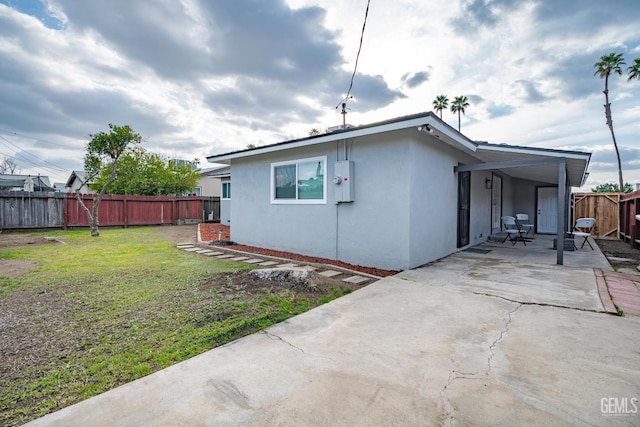 exterior space featuring a yard, a patio, a fenced backyard, and stucco siding