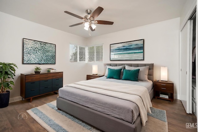 bedroom featuring dark wood-style floors, a closet, ceiling fan, and baseboards