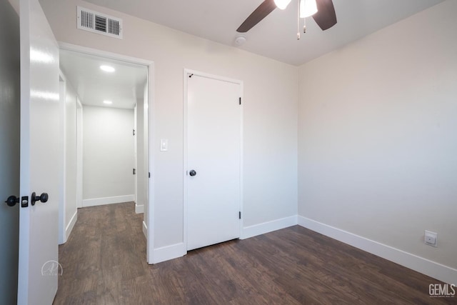 unfurnished bedroom featuring ceiling fan, dark wood-type flooring, visible vents, and baseboards