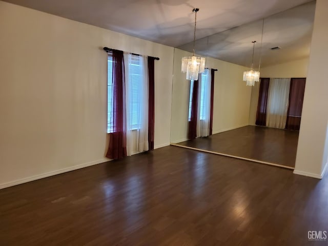 unfurnished room with dark hardwood / wood-style flooring and a chandelier