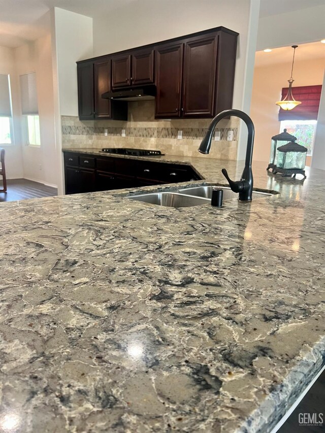 9909 Stockholm Pl, Bakersfield, CA 93306 - kitchen featuring sink, tasteful backsplash, decorative light fixtures, dark brown cabinets, and black gas cooktop