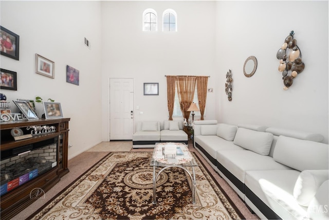 carpeted living room featuring a towering ceiling