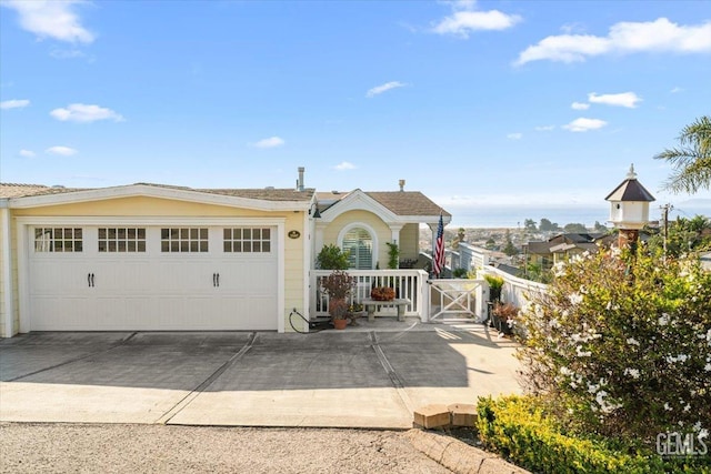 view of front of house featuring an attached garage, a gate, and concrete driveway