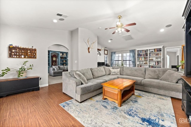 living room with lofted ceiling, ceiling fan, and wood-type flooring