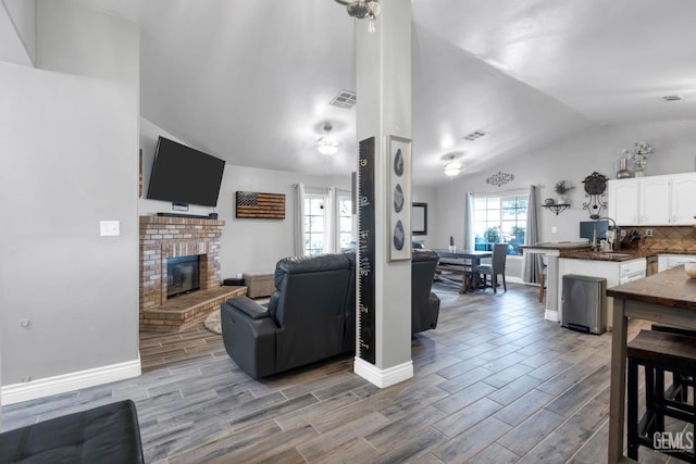 13160 Game Set Way, Bakersfield, CA 93306 - living area featuring vaulted ceiling, wood tiled floors, and a fireplace