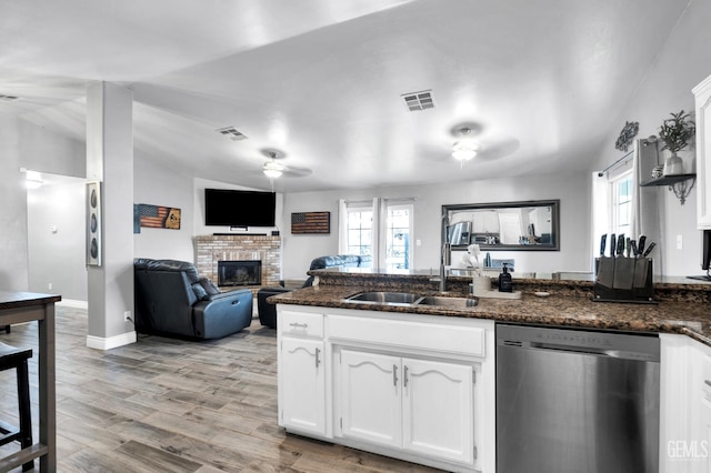 13160 Game Set Way, Bakersfield, CA 93306 - kitchen featuring stainless steel dishwasher, a glass covered fireplace, ceiling fan, white cabinetry, and dark stone countertops