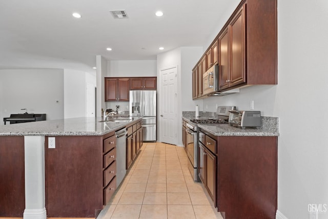 9904 Toscana Dr, Bakersfield, CA 93306 - kitchen with appliances with stainless steel finishes, a center island with sink, light stone countertops, light tile patterned floors, and recessed lighting