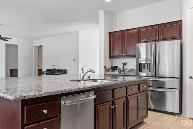 9904 Toscana Dr, Bakersfield, CA 93306 - kitchen with appliances with stainless steel finishes, light stone counters, light tile patterned floors, ceiling fan, and a center island with sink