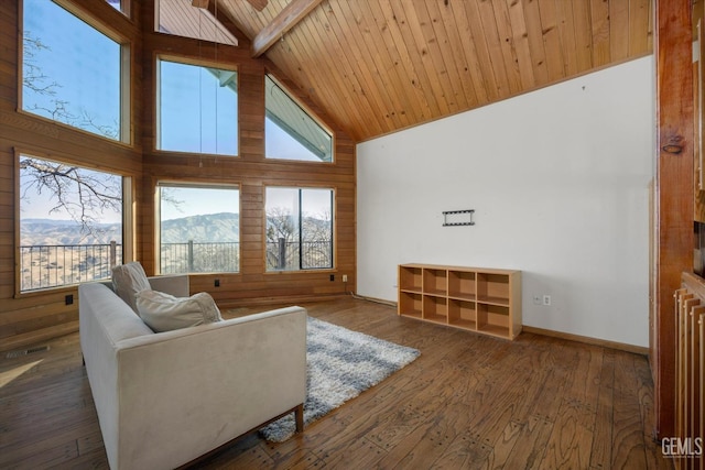 living room featuring wood ceiling, dark wood-type flooring, wooden walls, high vaulted ceiling, and a mountain view