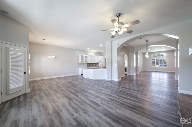 14211 Cedar Creek Ave, Bakersfield, CA 93314 - unfurnished living room featuring arched walkways, ceiling fan, dark wood-type flooring, and recessed lighting