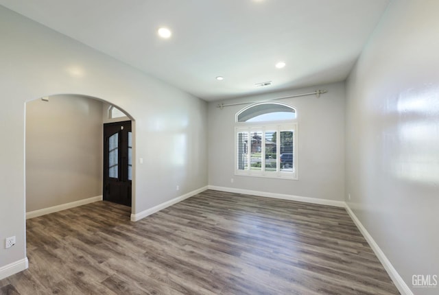 14211 Cedar Creek Ave, Bakersfield, CA 93314 - unfurnished room featuring arched walkways, wood finished floors, and recessed lighting