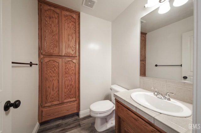 14211 Cedar Creek Ave, Bakersfield, CA 93314 - half bath featuring vanity, wood finished floors, and backsplash