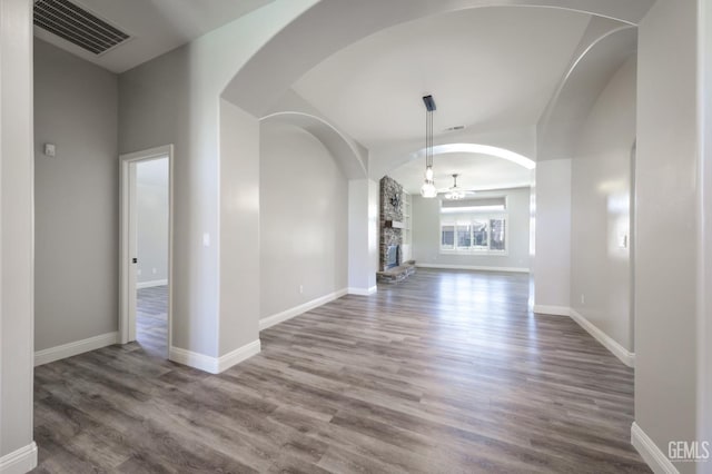 14211 Cedar Creek Ave, Bakersfield, CA 93314 - unfurnished living room featuring arched walkways, wood finished floors, ceiling fan, and a fireplace