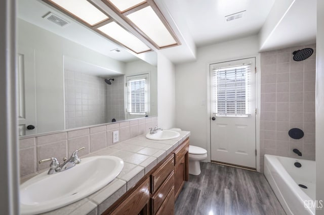 14211 Cedar Creek Ave, Bakersfield, CA 93314 - bathroom with healthy amount of natural light, double vanity, wood finished floors, and shower / bath combination