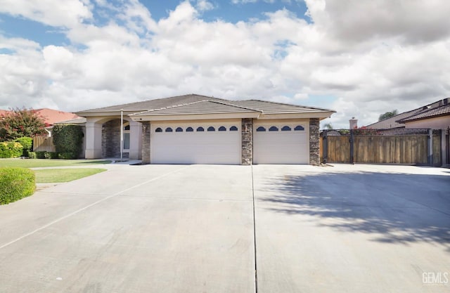 14211 Cedar Creek Ave, Bakersfield, CA 93314 - ranch-style home featuring stone siding, a garage, a tiled roof, and driveway