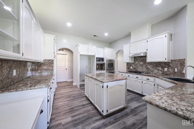 14211 Cedar Creek Ave, Bakersfield, CA 93314 - kitchen with arched walkways, stainless steel appliances, light stone counters, white cabinets, and recessed lighting