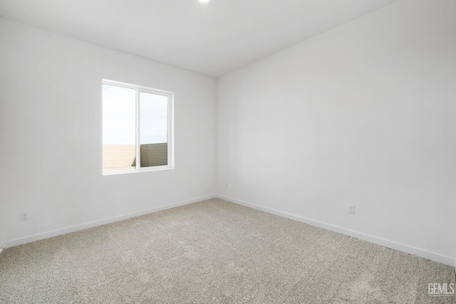 unfurnished room featuring carpet and baseboards