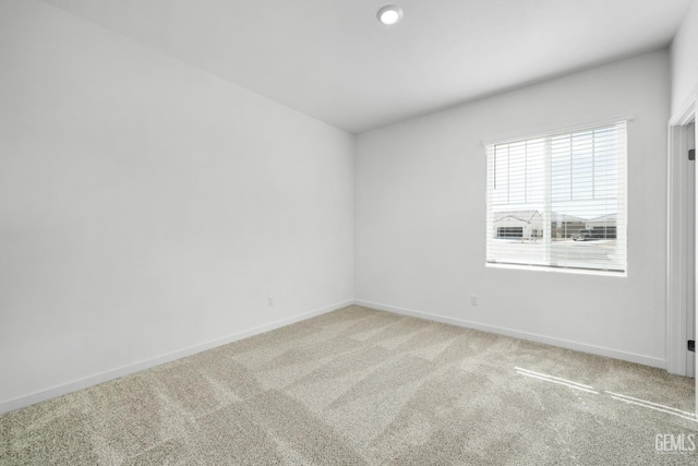 spare room with light colored carpet and baseboards