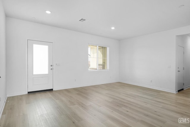 interior space with baseboards, light wood finished floors, visible vents, and recessed lighting