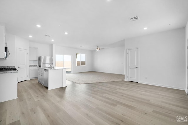 kitchen featuring open floor plan, stainless steel appliances, light wood-style flooring, and visible vents