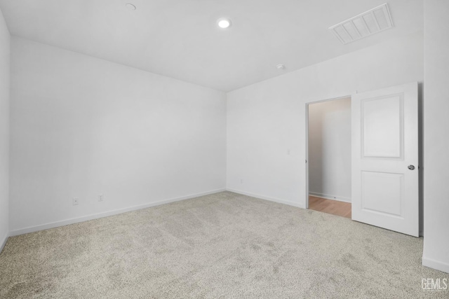 unfurnished room with carpet floors, recessed lighting, visible vents, and baseboards