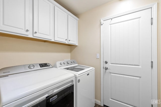 washroom with cabinet space and washer and clothes dryer
