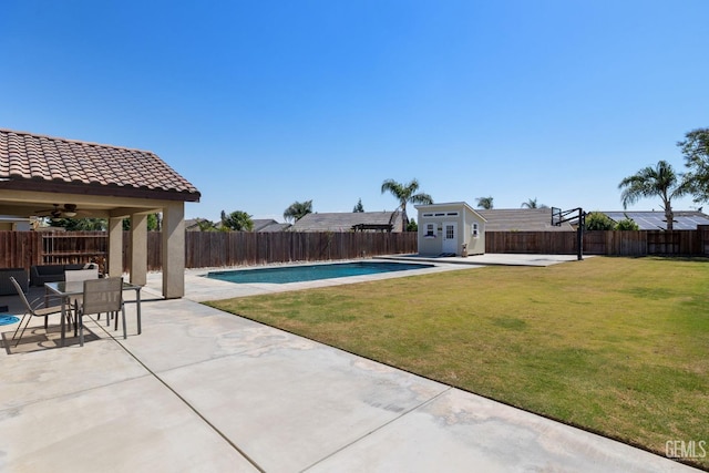 view of swimming pool with a patio, a fenced backyard, a yard, and an outdoor structure
