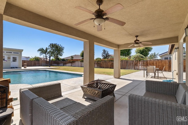 view of pool featuring a fenced backyard, an outdoor living space with a fire pit, and a patio area