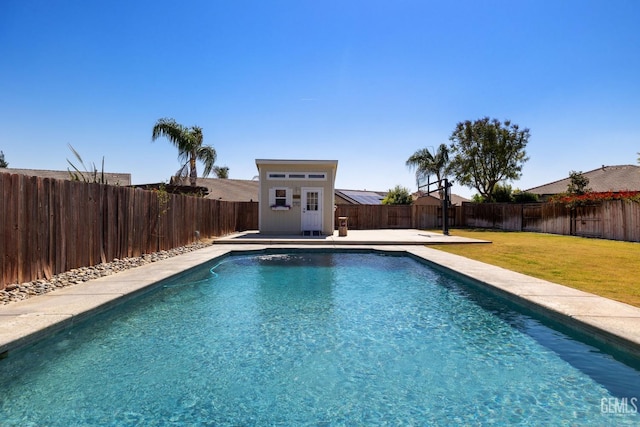view of pool with a fenced backyard, an outbuilding, a fenced in pool, and a yard