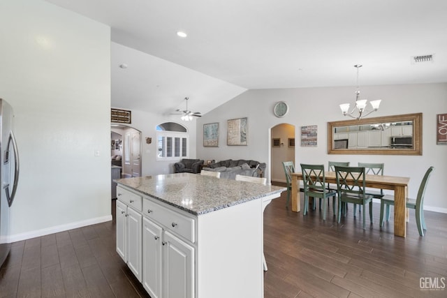 kitchen with dark wood-style floors, white cabinets, arched walkways, ceiling fan with notable chandelier, and vaulted ceiling
