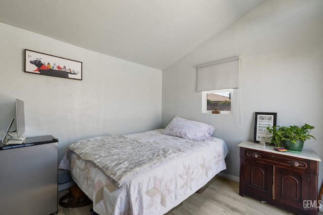 bedroom featuring light wood-style flooring and lofted ceiling
