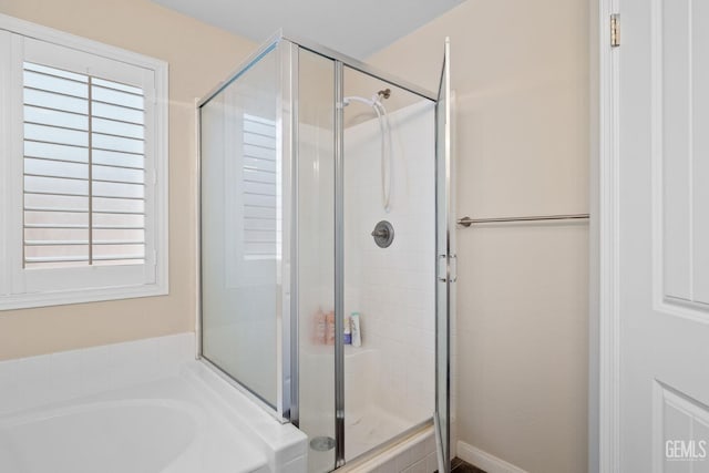 bathroom featuring a shower stall and a garden tub