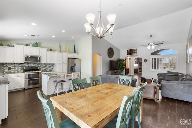 dining space with arched walkways, ceiling fan with notable chandelier, dark wood-style flooring, and visible vents