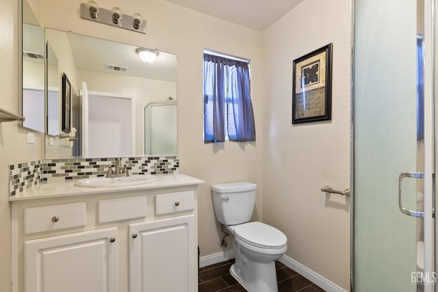 bathroom featuring visible vents, wood finished floors, toilet, baseboards, and backsplash