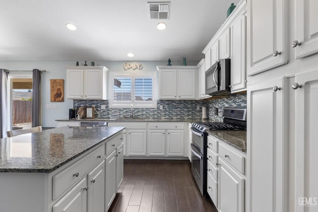 kitchen featuring white cabinets, appliances with stainless steel finishes, and a healthy amount of sunlight