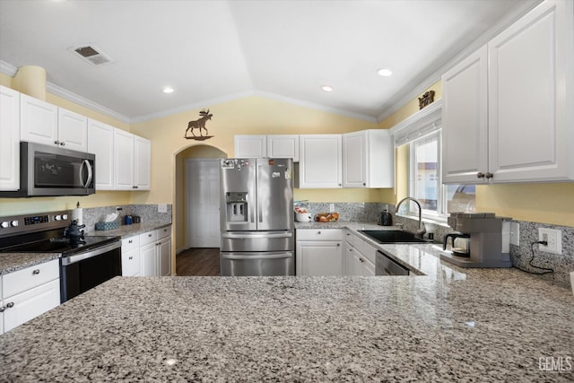 kitchen featuring stainless steel appliances, a sink, light stone countertops, white cabinets, and ornamental molding