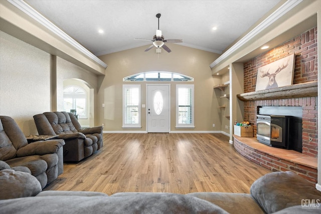 living area with a ceiling fan, wood finished floors, crown molding, plenty of natural light, and baseboards