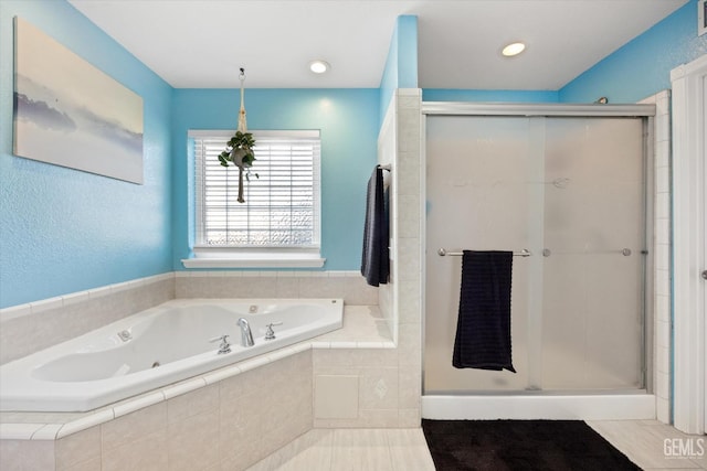 full bathroom featuring a whirlpool tub and a shower stall