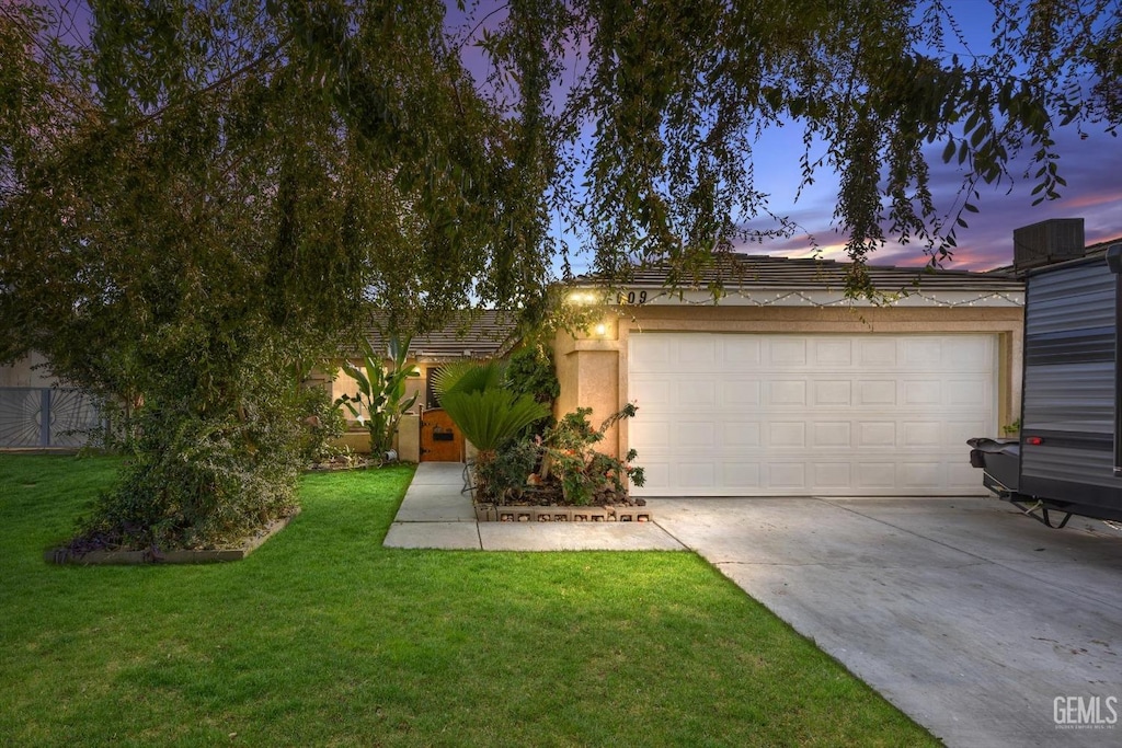 view of front of home featuring a lawn and a garage