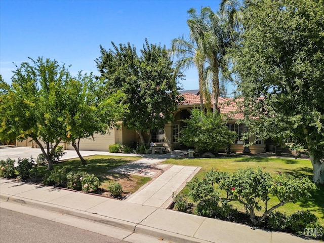 7310 Clifftop Way, Bakersfield, CA 93306 - view of property hidden behind natural elements featuring roof mounted solar panels, a front lawn, concrete driveway, and an attached garage