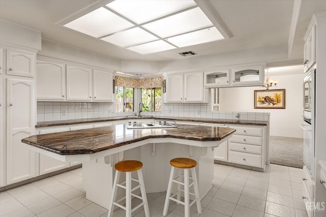7310 Clifftop Way, Bakersfield, CA 93306 - kitchen with a breakfast bar, white cabinets, and light tile patterned floors