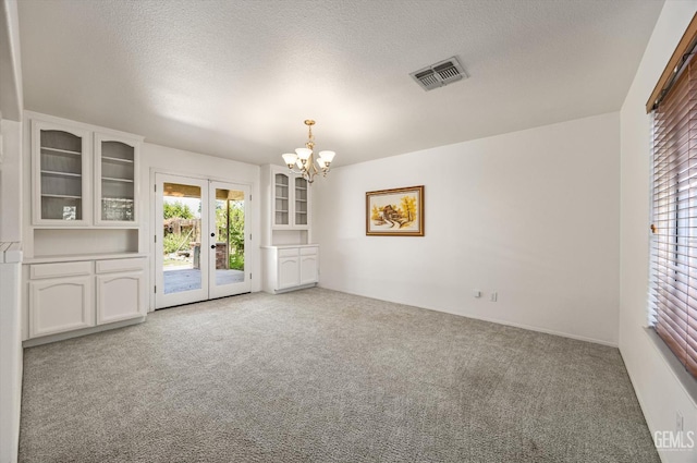 7310 Clifftop Way, Bakersfield, CA 93306 - unfurnished dining area featuring french doors, carpet, a chandelier, and a textured ceiling