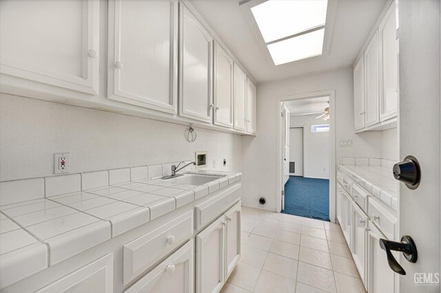 7310 Clifftop Way, Bakersfield, CA 93306 - laundry area featuring washer hookup, cabinet space, hookup for an electric dryer, light tile patterned flooring, and ceiling fan