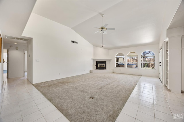 7310 Clifftop Way, Bakersfield, CA 93306 - unfurnished living room with light tile patterned floors, ceiling fan, vaulted ceiling, light carpet, and a tile fireplace