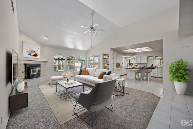 7310 Clifftop Way, Bakersfield, CA 93306 - living area with a ceiling fan, light tile patterned floors, a fireplace, plenty of natural light, and high vaulted ceiling