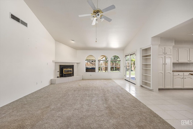 7310 Clifftop Way, Bakersfield, CA 93306 - unfurnished living room with ceiling fan, high vaulted ceiling, light tile patterned floors, a fireplace, and light colored carpet