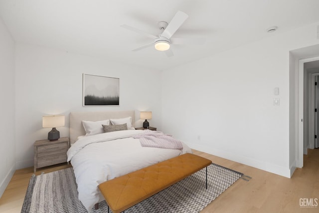 bedroom featuring light wood-type flooring, a ceiling fan, and baseboards