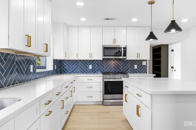 kitchen with stainless steel appliances, light countertops, visible vents, white cabinetry, and light wood-type flooring