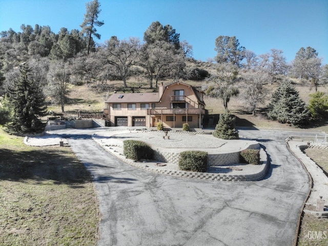 view of front of home featuring a garage and a balcony